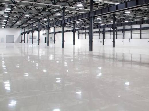 Large warehouse with a glossy light-gray high-build commercial epoxy floor