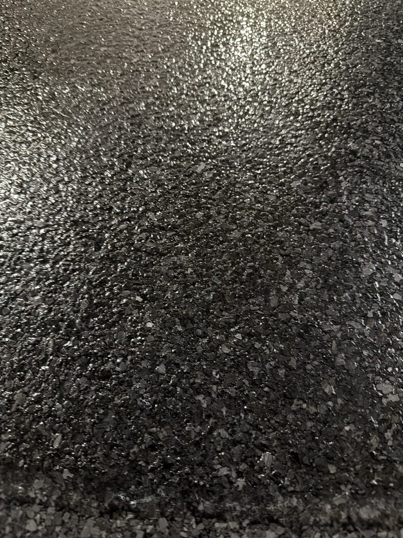 Close-up of a glossy black flake epoxy floor finish
