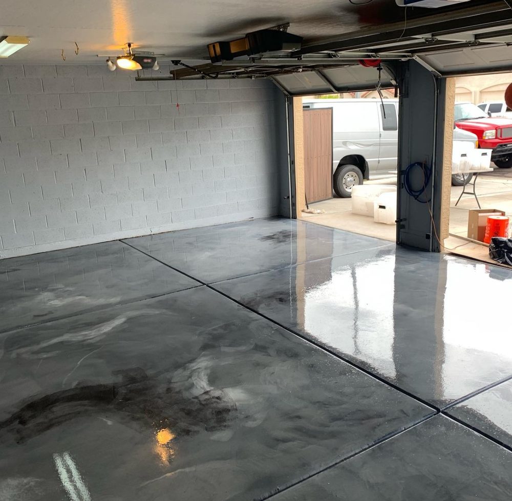 Gray and charcoal metallic epoxy garage floor with a glossy, marbled liquid-metal pattern